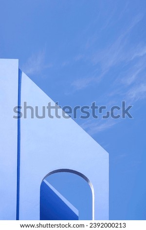 Two arch concrete facade walls on high section of vintage house building against blue sky background in vertical frame, exterior architecture background in street minimal style Royalty-Free Stock Photo #2392000213