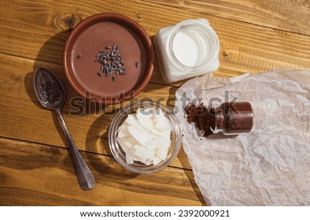 Chocolate panna cotta with coconut milk, vegan chocolate pudding with agar-agar and extra-dark cocoa powder. Coconut milk, cocoa powder, chips and dry lavender next to a delicious Italian dessert Royalty-Free Stock Photo #2392000921