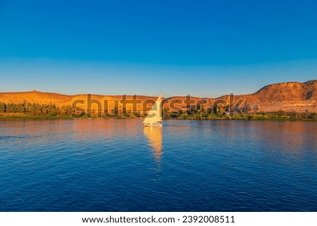Traditional felucca boat on the Nile River. Magnificent views of the Nile at sunset. Aswan, Egypt - October 19, 2023. Royalty-Free Stock Photo #2392008511