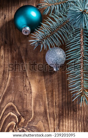 blue and silver christmas balls and pinetree branch on old wooden board with copyspace