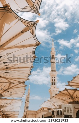 Umbrella Canopies Open At Nabawi Mosque Medina With Blue Beautiful Sky and Mosque Towers On The Background 