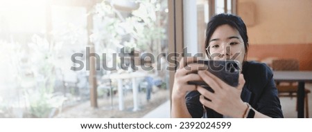 Young women enjoying coffee, using smart phone in cafe-panoramic banner