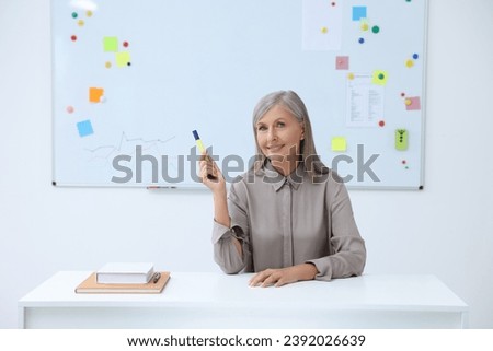 Happy professor giving lecture at desk in classroom, space for text
