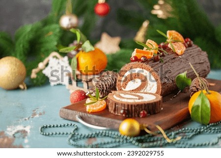 Yule log roll cake with chocolate ganache  on Christmas decorated background Royalty-Free Stock Photo #2392029755