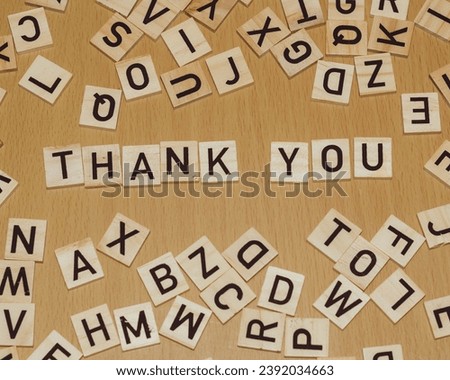 Thank you spelled out in wooden letters on a wooden background with copy space
