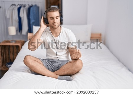 Young caucasian man doing yoga exercise sitting on bed at bedroom
