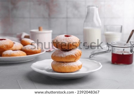 Hanukkah donuts with jelly and powdered sugar served on light grey table