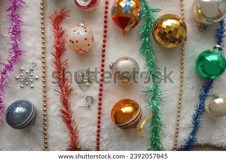 Colorful vintage Christmas ornaments and white faux fur blanket. Cute and kitschy Christmas decorations. Top view.