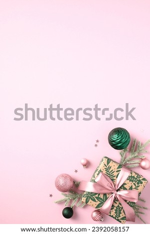 Pink Christmas background with gift box decorated fir tree ornament, ribbon bow, and confetti. Aesthetic vertical design for holiday cards, banners, and invitations. 