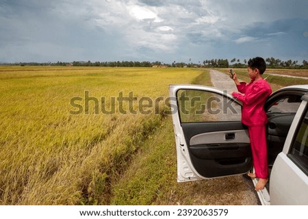 A boy taking picture,  photo of rice field 
