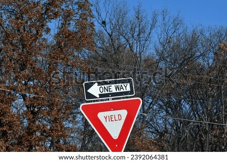Yield sign and one-way sign by trees