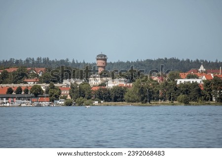 Panorama of the city of Giżycko from the lake with a beautiful historic water tower Royalty-Free Stock Photo #2392068483