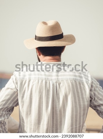 Back view picture of a man wearing a elegant hat.