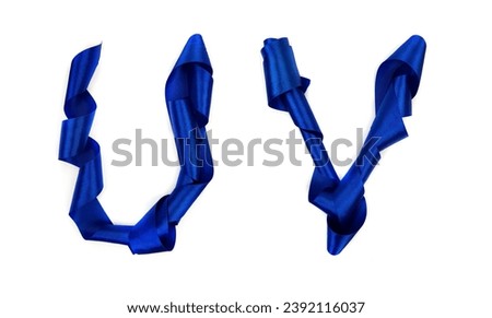 Dark blue fashion ribbon on white background. Letters U and V from blue silk strip. Alphabet.