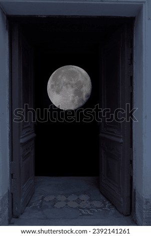 view of the full moon through the open double doors in the entrance                                Royalty-Free Stock Photo #2392141261