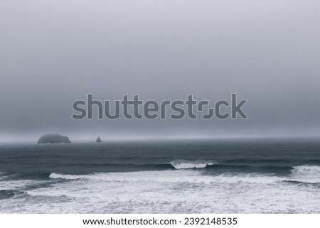Rocks off route 101 coastal highway during a storm, Image shows the rocks in the Pacific ocean with dark grey rain clouds and large waves
