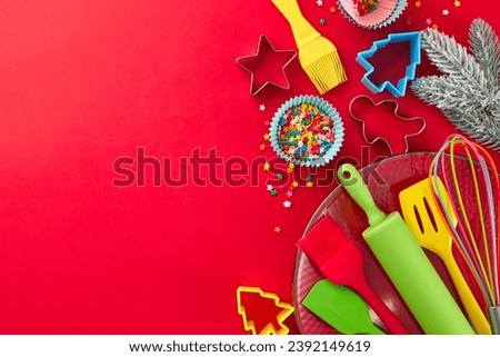 Yuletide delicacies concept. Top view shot of candies, pastry tools, baking molds, frosty fir twigs, snowflakes, colorful stars on red background with promo area