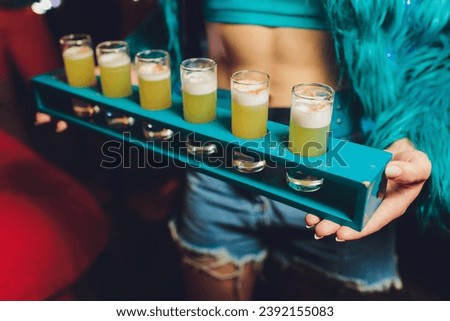 Waiter serving shots on a wooden tray