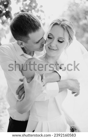 Gentle and happy newlyweds on a walk in the park. Wedding photo shoot.