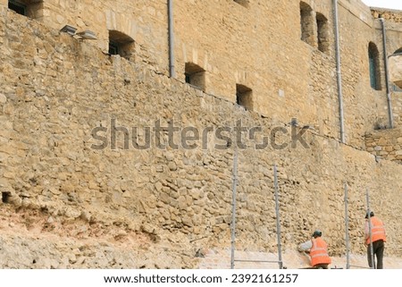 non edited picture of workers working on renewing and renovation of old history buildings castle walls