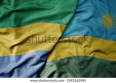 big waving national colorful flag of rwanda and national flag of gabon . macro