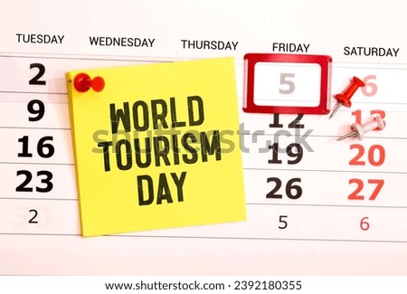 Happy world tourism day! Touristic clothes, hat, flip-flops, sunglasses and decorative items on light pastel background. Flat lay, top view. White photo frame with text WORLD TOURISM DAY