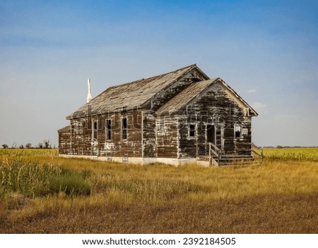 Old Abandoned and Weathered Wood Schoolhouse Out on the Western Frontier Royalty-Free Stock Photo #2392184505