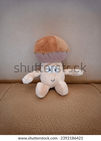 a mushroom character doll sits leaning on a chair