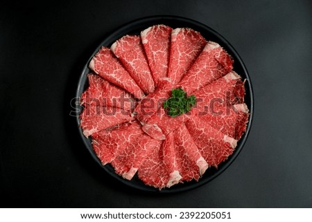 Sliced ​​beef Japanese style beef slices Sliced ​​beef in a black plate on a black background Aikyu Yakiniku Shabu Pictures for menu design
