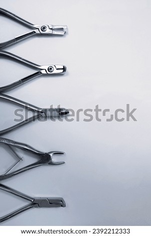 Dentist pliers on a gray background. Dentist equipment and tools