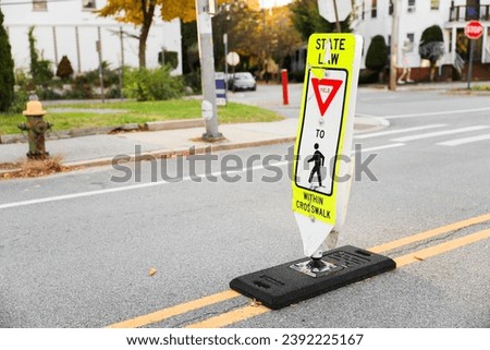 Pedestrian sign on bustling city street guiding pedestrians safely across, urban safety concept