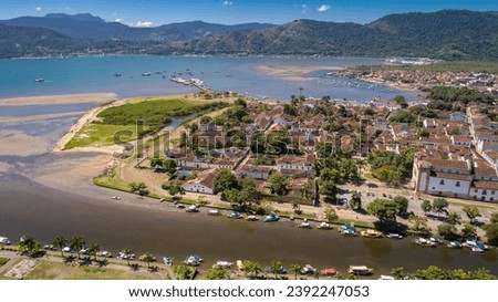 Aerial view to historic town Paraty with tidal river, sea and green mountains in background on a su