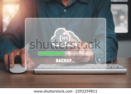 Backup concept, Business person hand touching backup icon on cirtual screen. Royalty-Free Stock Photo #2392259811