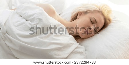 Woman Sleeping In Bed With Nasal Strip On Nose On White Linen. Stop Drug-free Snoring Solution. Adhesive Bandage For Better Healthy Breathing. Horizontal Plane. Female Takes Calm Sleep Every Night. Royalty-Free Stock Photo #2392284733