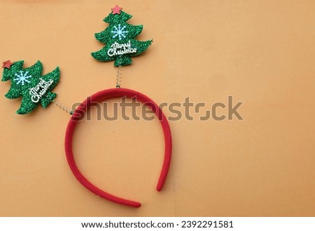 Beautiful headband funny christmas trees isolate on a light orange backdrop.
concept of joyful Christmas party,New year is coming soon, festive season decoration with Christmas elements