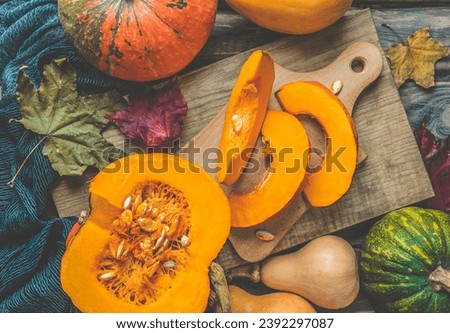 Pumpkins on a wooden rustic background. Yellow autumn harvest pumpkins on the festive table. Fall holidays, halloween, thanksgiving day, food concept.Kitchen interior with cutting boards and pumpkins