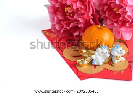 Chinese New Year of the dragon festival concept. Orange, red envelopes, two dragons and gold ingot decorated with plum blossom on white background. copy space for text. Royalty-Free Stock Photo #2392305461