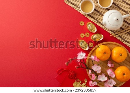 Auspicious New Year Banquet Arrangement: top view tea ceremony, bamboo mat, sycee, Hong Bao, dragon charm wall hanging, fruits, sakura on red backdrop. Advertise against this symbolically rich tableau