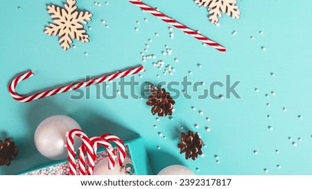Christmas composition with gift boxes, candy cane, pine cone, snowflakes on a light blue background.