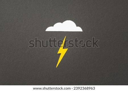 White cut out paper cloud and yellow lightning on black background. weather concept. Energy and electricity. Nature