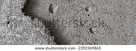 Texture of an old cracked concrete wall. Grungy gray concrete surface with shadow. Wide panoramic background for design.