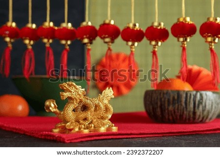 Festive composition with golden dragon figurine, traditional Chinese decor and mandarins on black table. New Year celebration