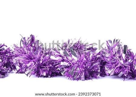Purple Christmas tinsel on white background, closeup Royalty-Free Stock Photo #2392373071