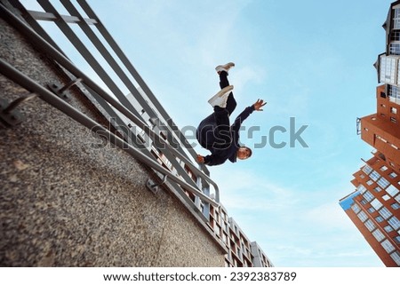 Athlete man, young guy jumping, flips of wall, practice Parkour in public park among high-rise buildings over sunrise. Eye fish filter. Concept of lifestyle, sport, freestyle, activity, motion. Ad