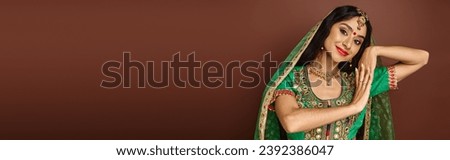 beautiful young indian woman in national wear gesturing and smiling happily at camera, banner