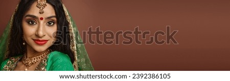 cheerful attractive indian woman with traditional accessories and bindi smiling at camera, banner