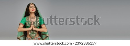 beautiful indian woman in national costume with accessories praying and looking away, banner