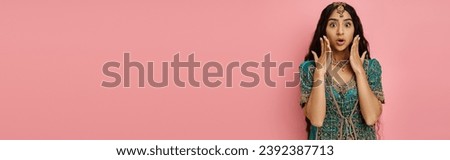 amazed indian woman in national costume posing with hands near face with open mouth, banner