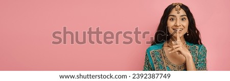 jolly indian woman in traditional costume showing silence gesture and looking at camera, banner