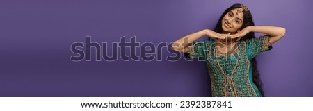 joyous indian woman in national costume posing with hands under chin and smiling at camera, banner